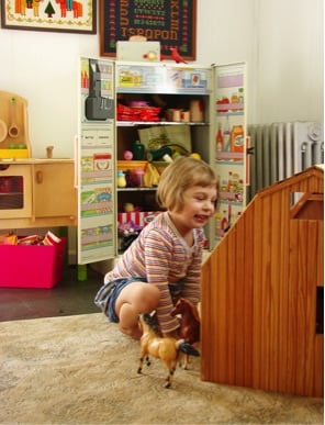 little girl playing with toys in room